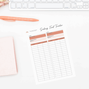 picture of a desk with a keyboard and pen next to a paper of a tracker for sinking funds